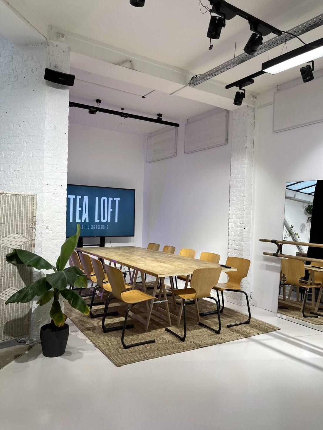 Grande table de réunion et écran dans l'espace bas du Tea Loft